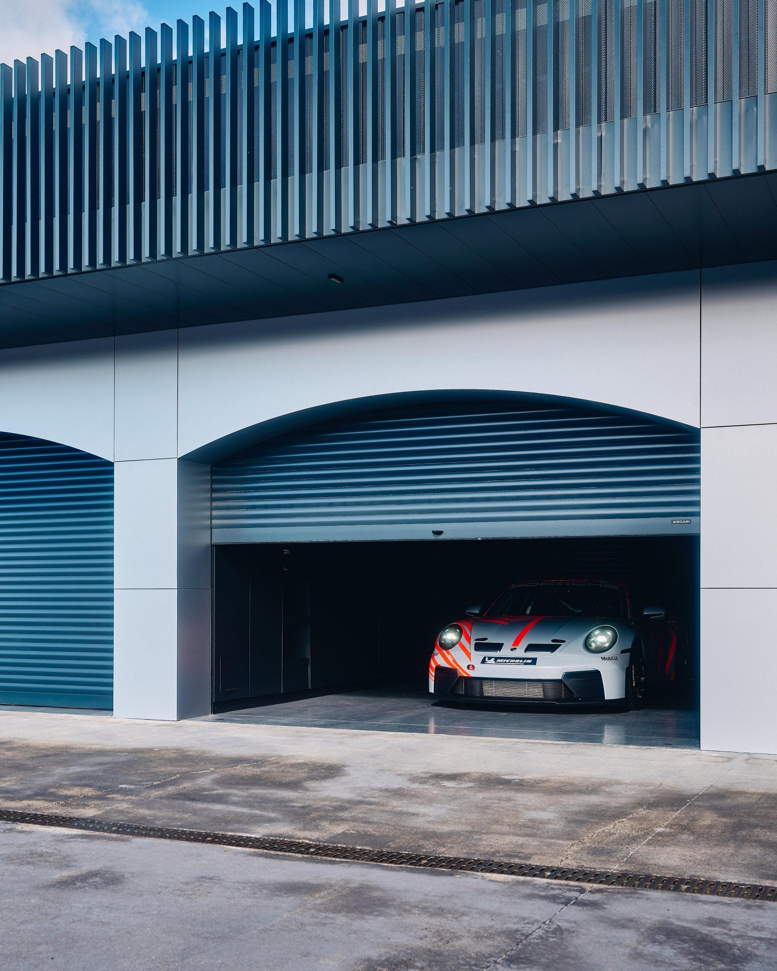 Porsche 911 Challenge positioned in a garage at a racing circuit