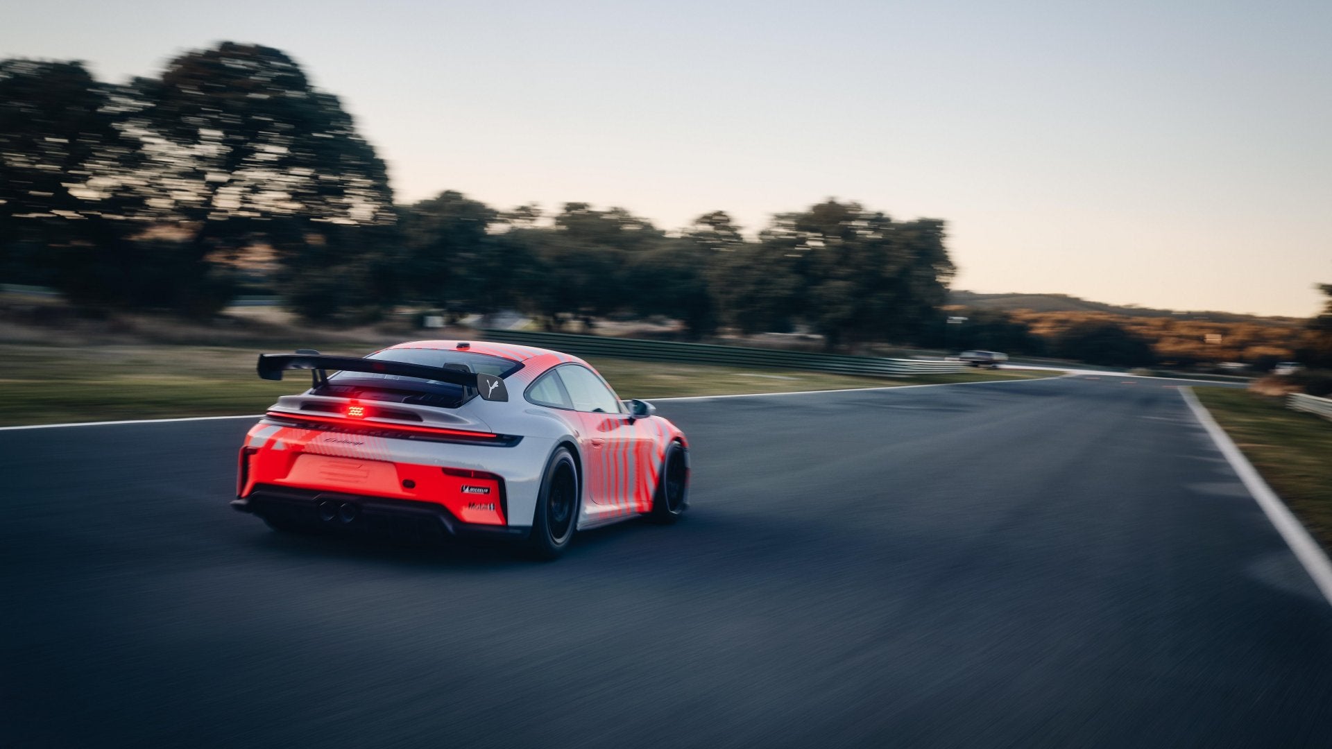 Porsche 911 Challenge driving away along a racing circuit